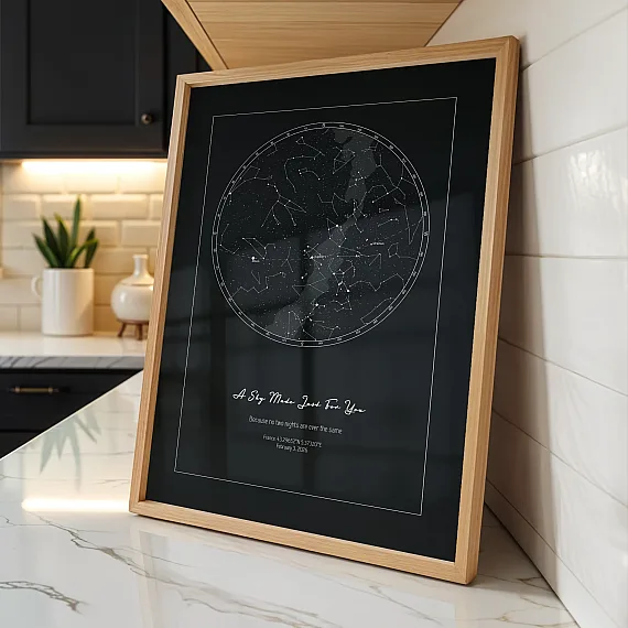 Framed Birthday Star Map poster with dark constellation design displayed in modern kitchen.